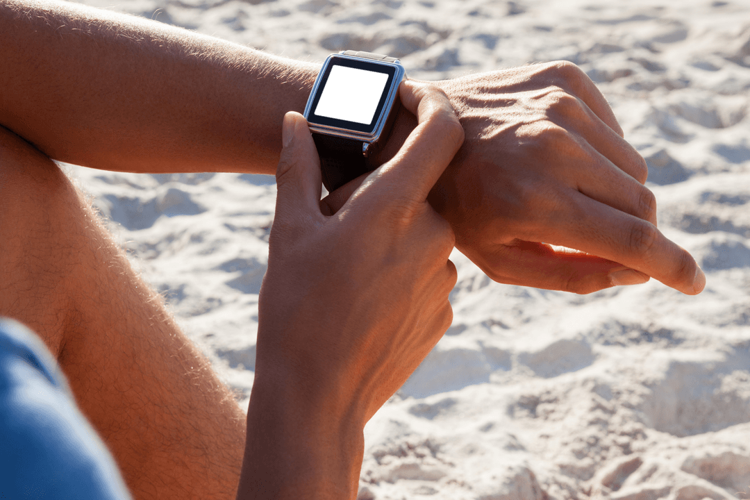 Man Checking Smartwatch Relaxing on Sunny Beach