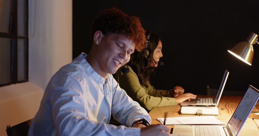 Diverse Colleagues Working Late With Laptops and Headsets