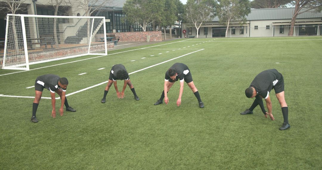 Soccer Players Stretching on Field for Practice Session