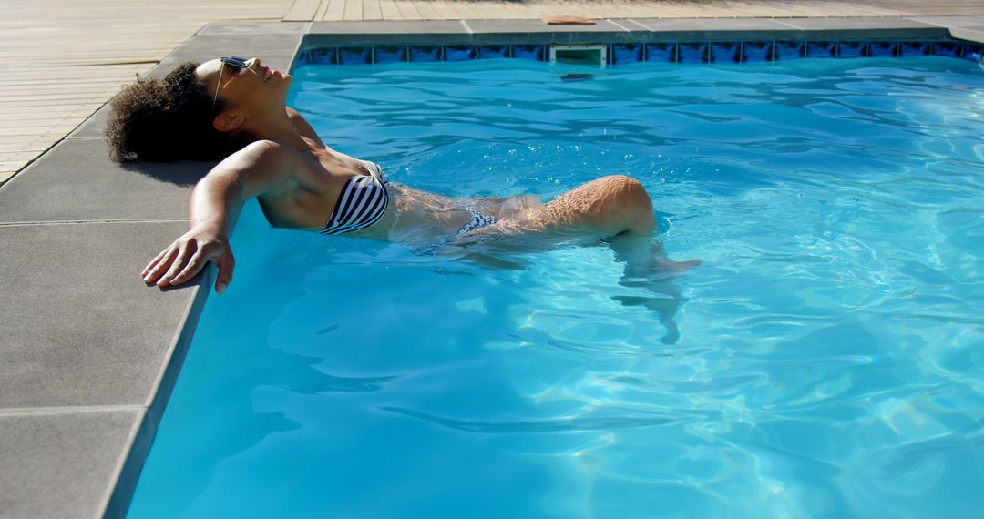 Woman relaxing in swimming pool on sunny day - Free Images, Stock Photos and Pictures on Pikwizard.com