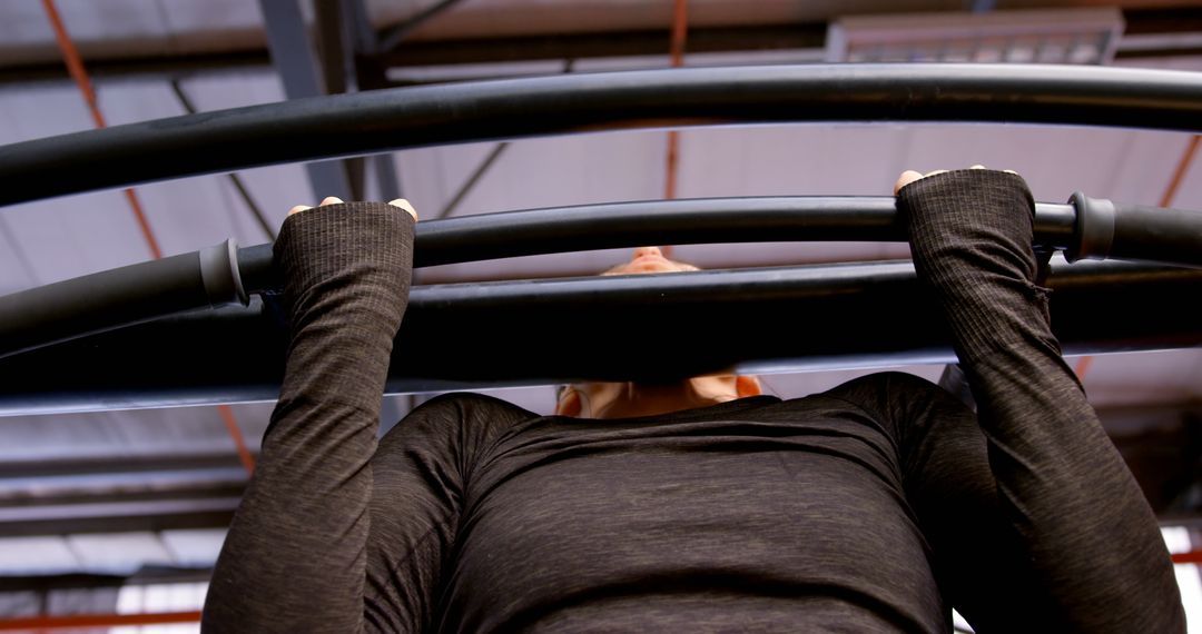 Caucasian Woman Determined Achieving Pull-Up at Gym
