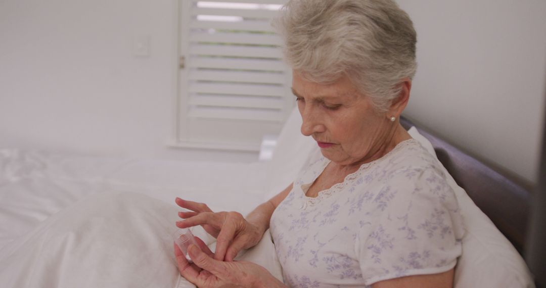 Elderly Woman Taking Medications in Bedroom - Free Images, Stock Photos and Pictures on Pikwizard.com