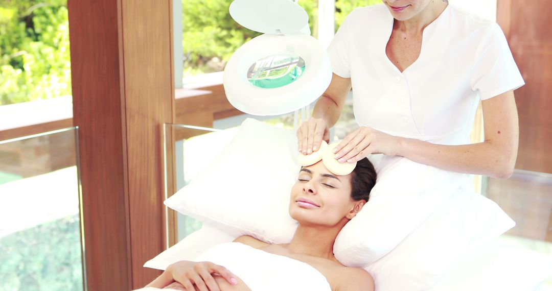 An esthetician provides a relaxing facial to a young woman in a tranquil spa setting. - Free Images, Stock Photos and Pictures on Pikwizard.com