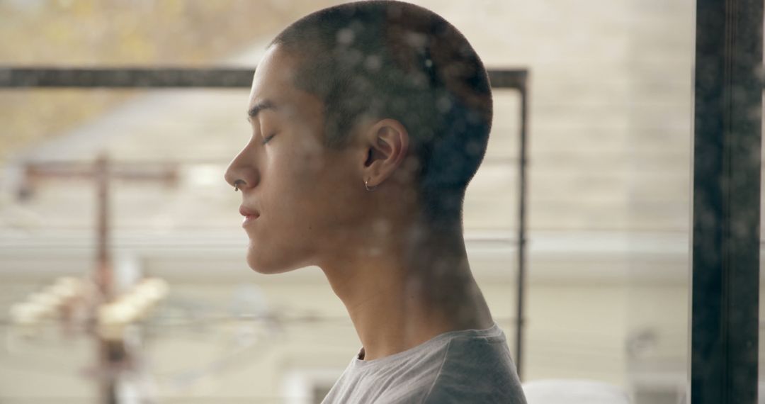 Content Young Man Meditating by Window with Serene Facial Expression - Free Images, Stock Photos and Pictures on Pikwizard.com