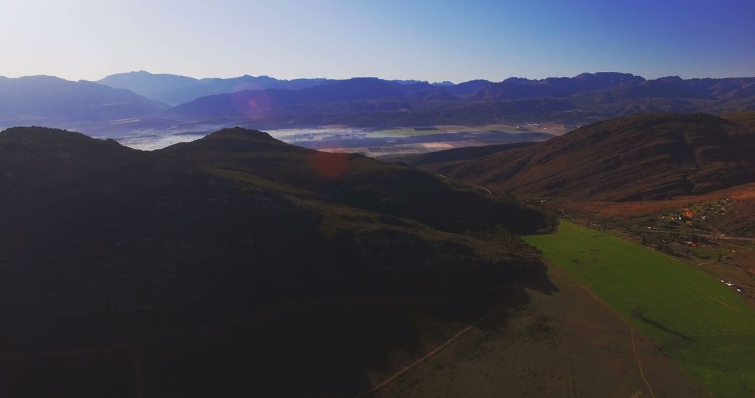 Aerial View of Verdant Valley with Misty Mountains at Dawn