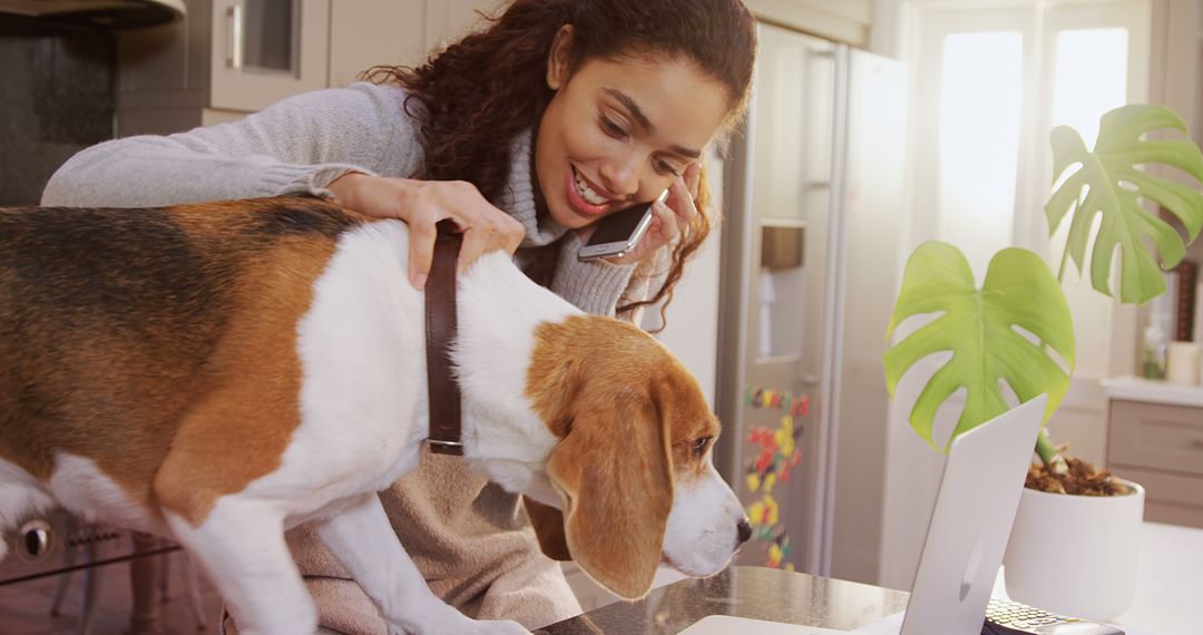 Woman Talking on Phone and Petting Beagle Dog in Kitchen - Free Images, Stock Photos and Pictures on Pikwizard.com