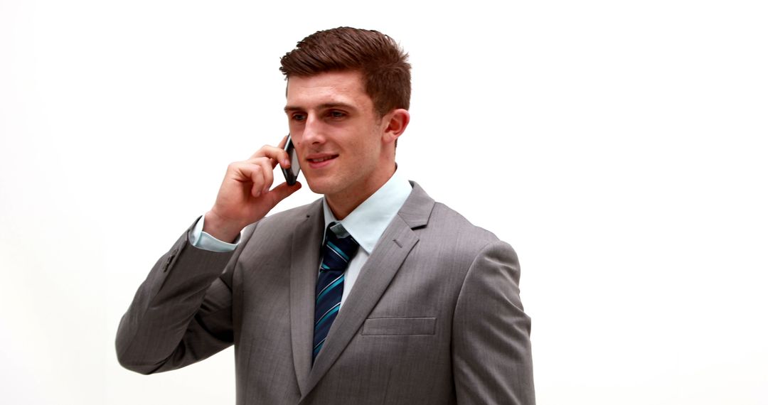 Confident Businessman Talking on Smartphone in Suit Against White Background - Free Images, Stock Photos and Pictures on Pikwizard.com