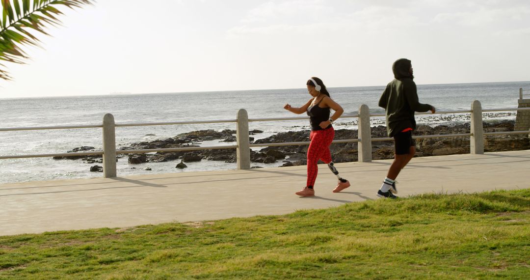 Two Joggers Exercising Along Seaside Path During Daytime - Free Images, Stock Photos and Pictures on Pikwizard.com