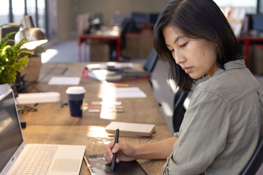 Focused Designer Using Graphics Tablet at Modern Office Desk