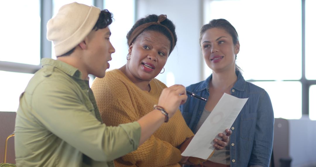 Multicultural Team Reviewing Document on Office Sofa during Casual Brainstorming Session