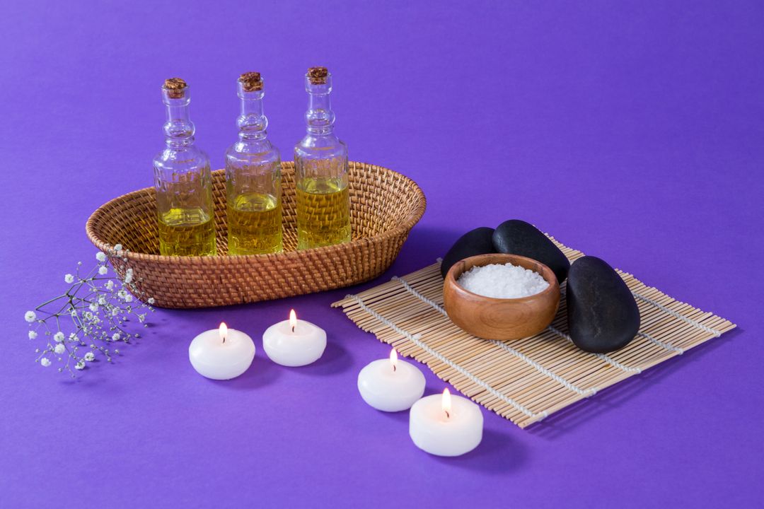 Spa Accessories with Essential Oils and Candles on Purple Background - Free Images, Stock Photos and Pictures on Pikwizard.com