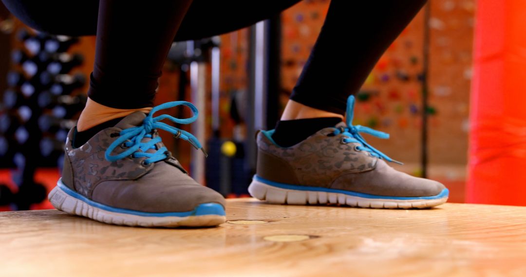 Athlete Performing Box Jump Squat in Modern Gym Setting