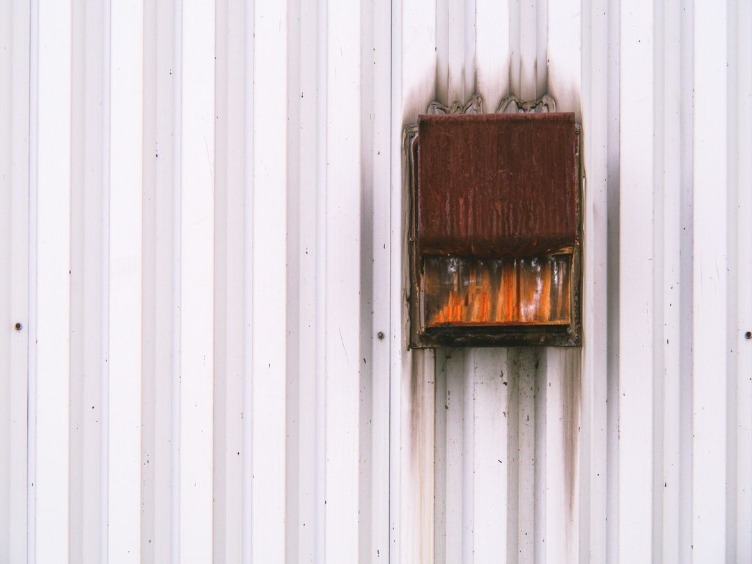 Rusty Vent on White Corrugated Metal Surface