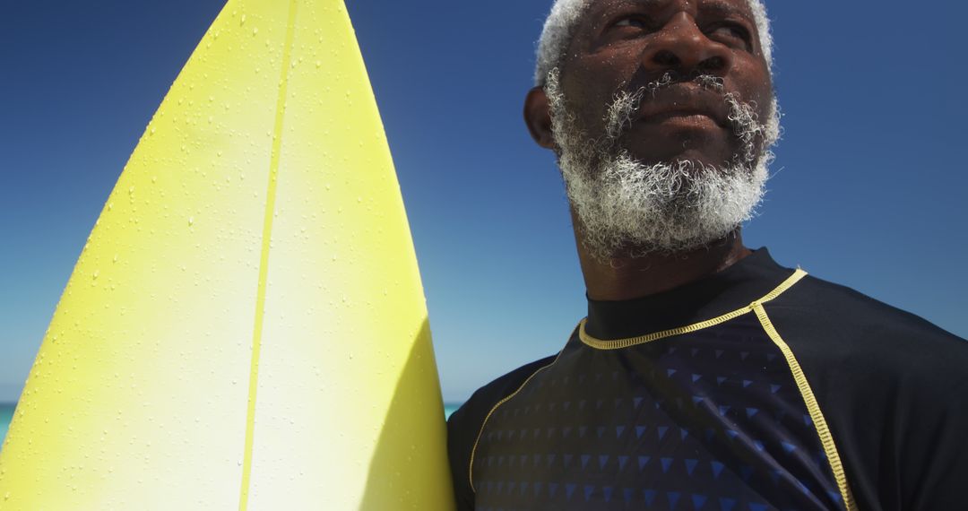 Elderly Man with Surfboard Enjoying Sunny Beach - Free Images, Stock Photos and Pictures on Pikwizard.com