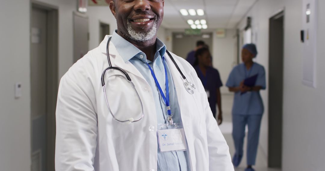 Confident Doctor Smiling in Hospital Hallway - Free Images, Stock Photos and Pictures on Pikwizard.com