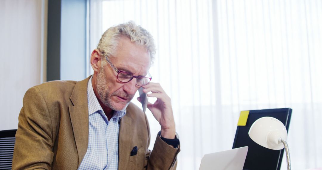 Senior businessman using smartphone and laptop in office - Free Images, Stock Photos and Pictures on Pikwizard.com