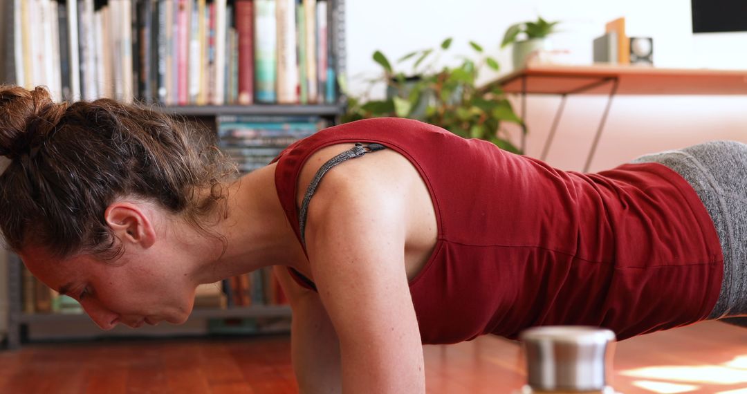 Woman Doing Push-ups at Home with Bookshelf Background - Free Images, Stock Photos and Pictures on Pikwizard.com