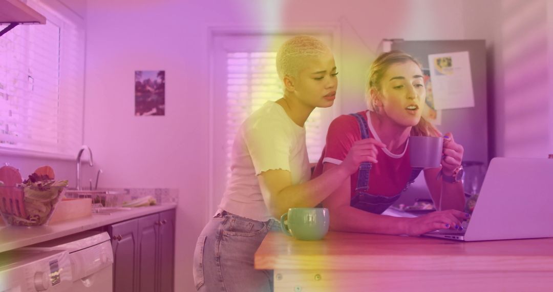 Friends Reviewing Content on Laptop in Colorful Kitchen Setting
