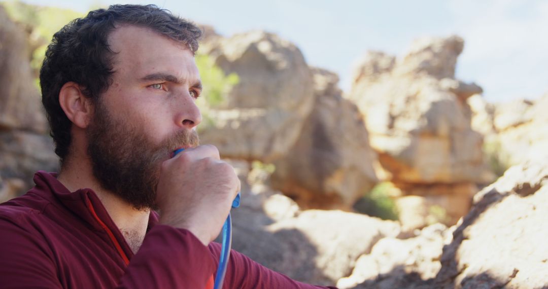 Bearded Hiker Staying Hydrated in Rocky Terrain - Free Images, Stock Photos and Pictures on Pikwizard.com