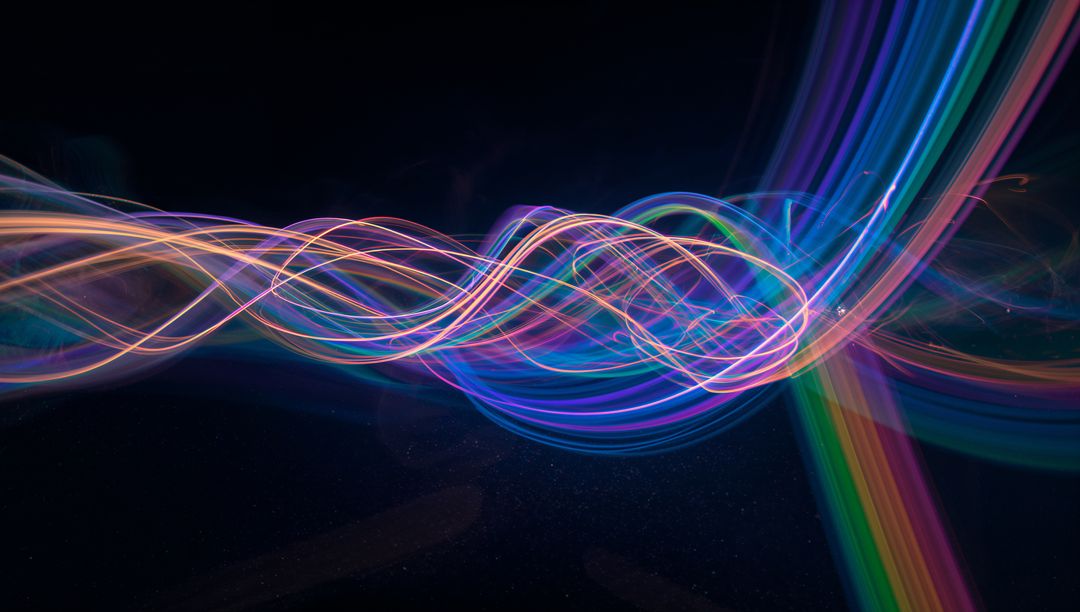 Vibrant Multicolored Abstract Light Trails in Dark Background
