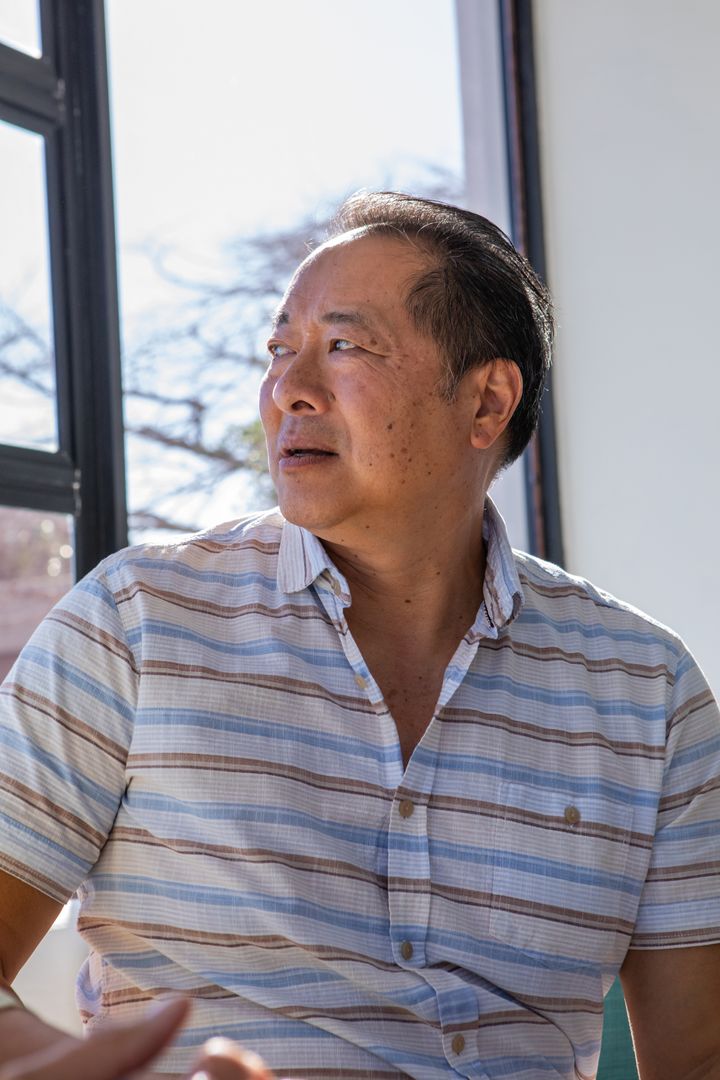 Senior Man Gazing Thoughtfully by Sunlit Window