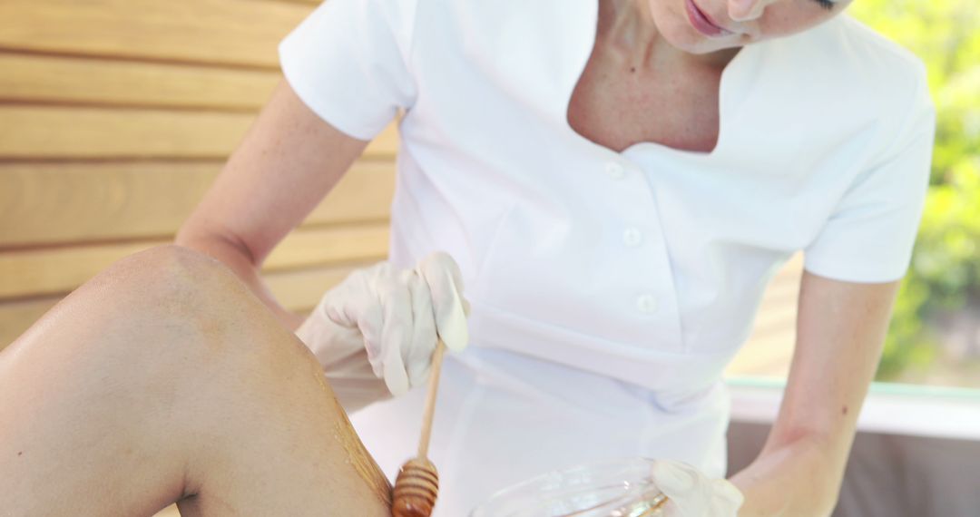 Beautician Applying Honey Wax for Leg Hair Removal - Free Images, Stock Photos and Pictures on Pikwizard.com