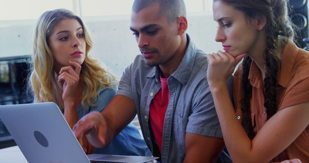 Diverse Young Adults Collaborating on Laptop Project Discussion