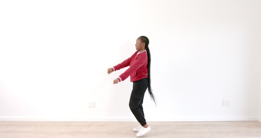 Joyful Woman Dancing in Red Jacket in Bright Minimalist Space