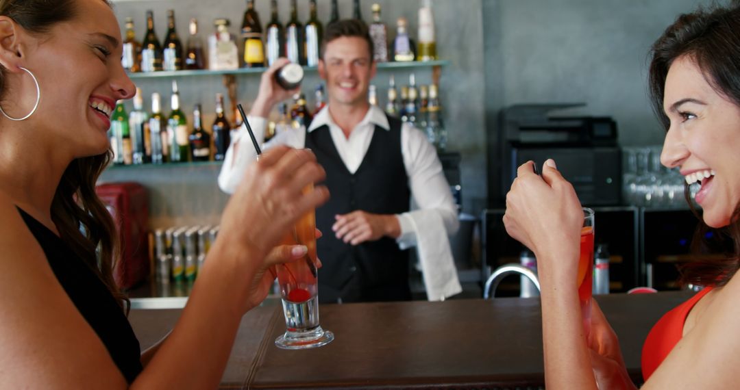 Two Women Enjoying Cocktails in Modern Bar with Smiling Bartender