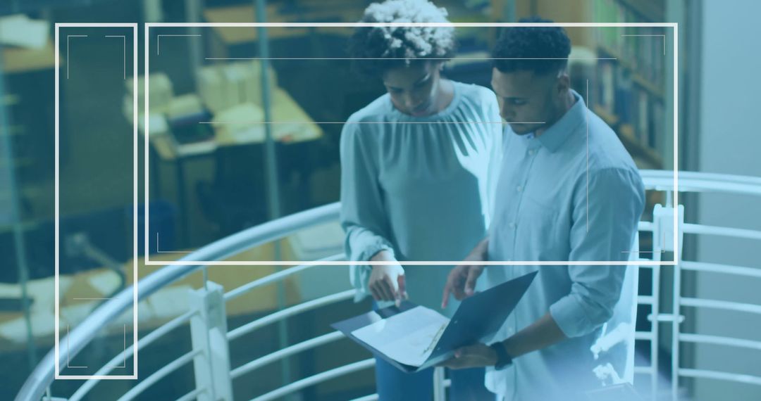 Collaborating Coworkers Analyzing Laptop Data on Modern Office Balcony