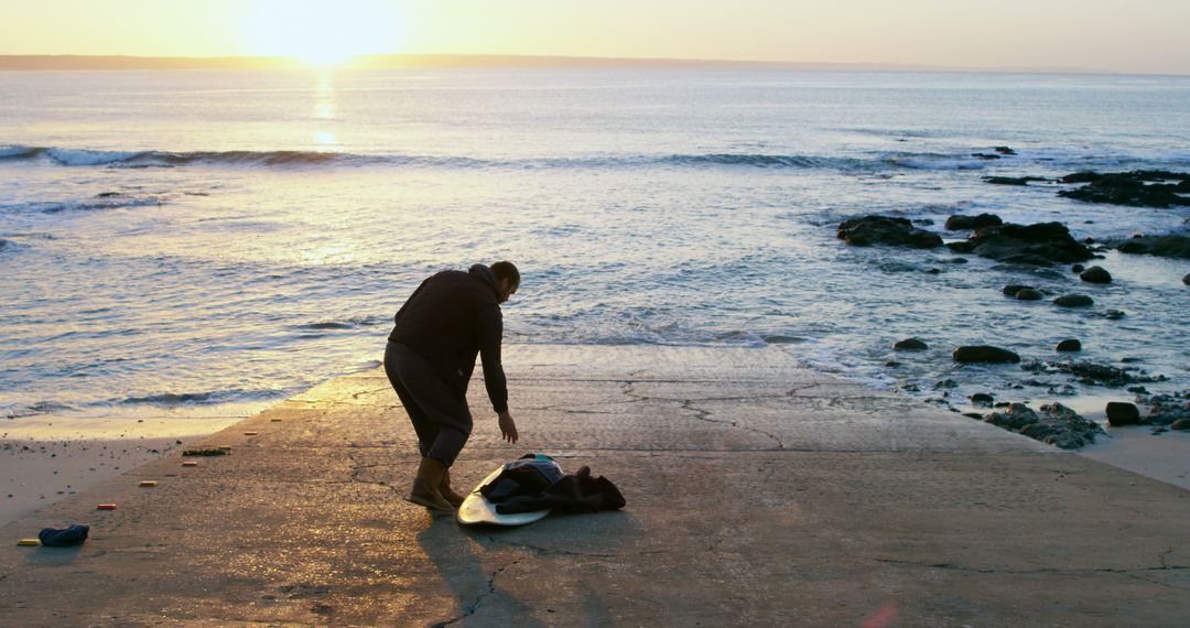 Surfer Preparing Board at Sunrise on Beach - Free Images, Stock Photos and Pictures on Pikwizard.com