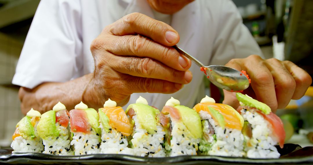 Sushi Chef Garnishing Fresh Sushi Roll with Fish Eggs - Free Images, Stock Photos and Pictures on Pikwizard.com