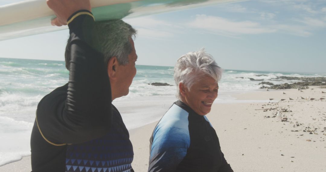 Senior Couple Happy with Surfboard Walking on Beach