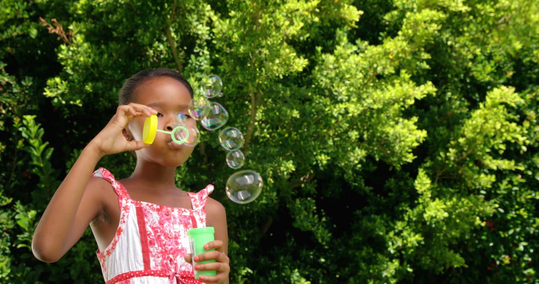 Young Girl Blowing Bubbles in Sunny Garden - Free Images, Stock Photos and Pictures on Pikwizard.com