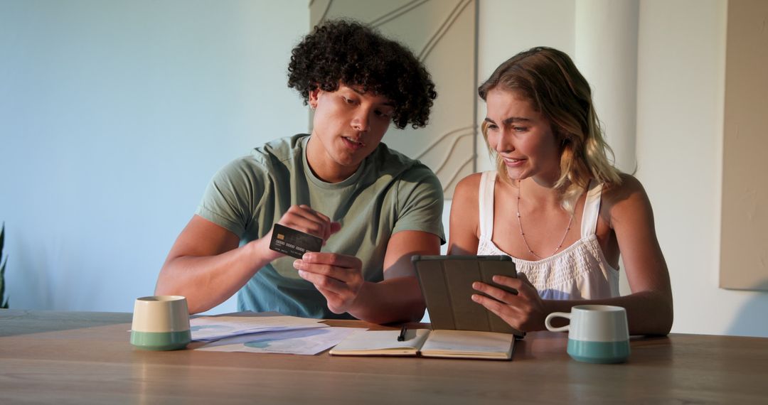 Couple Enthusiastically Planning Finances with Tablet