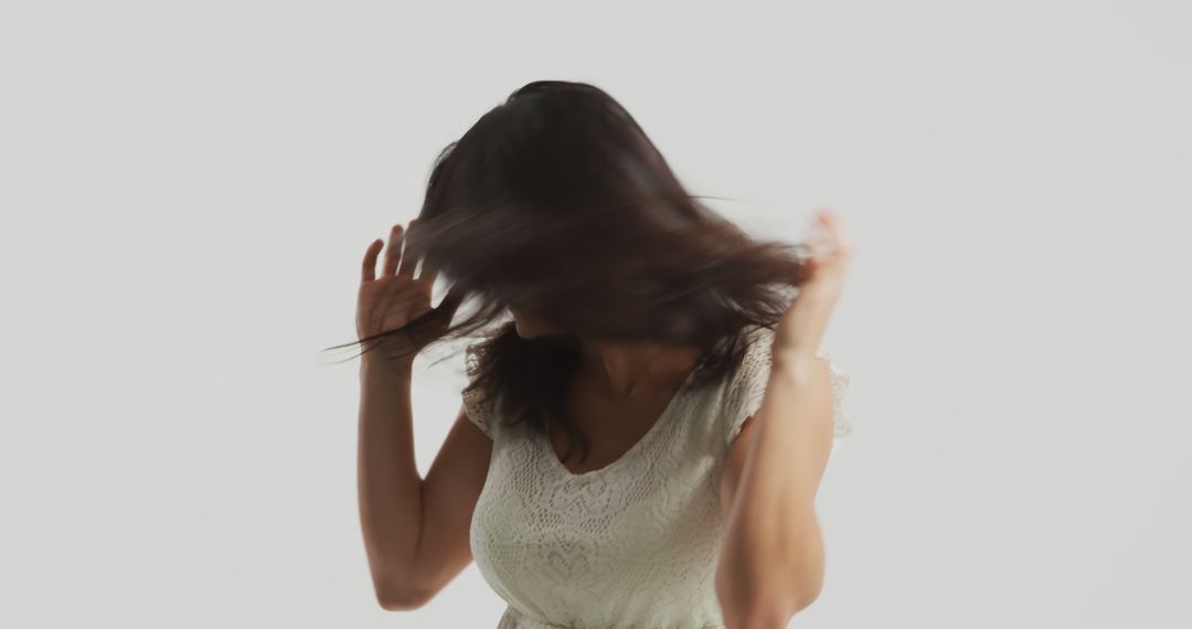 Woman Tossing Hair in a White Lace Dress on a Plain Background - Free Images, Stock Photos and Pictures on Pikwizard.com