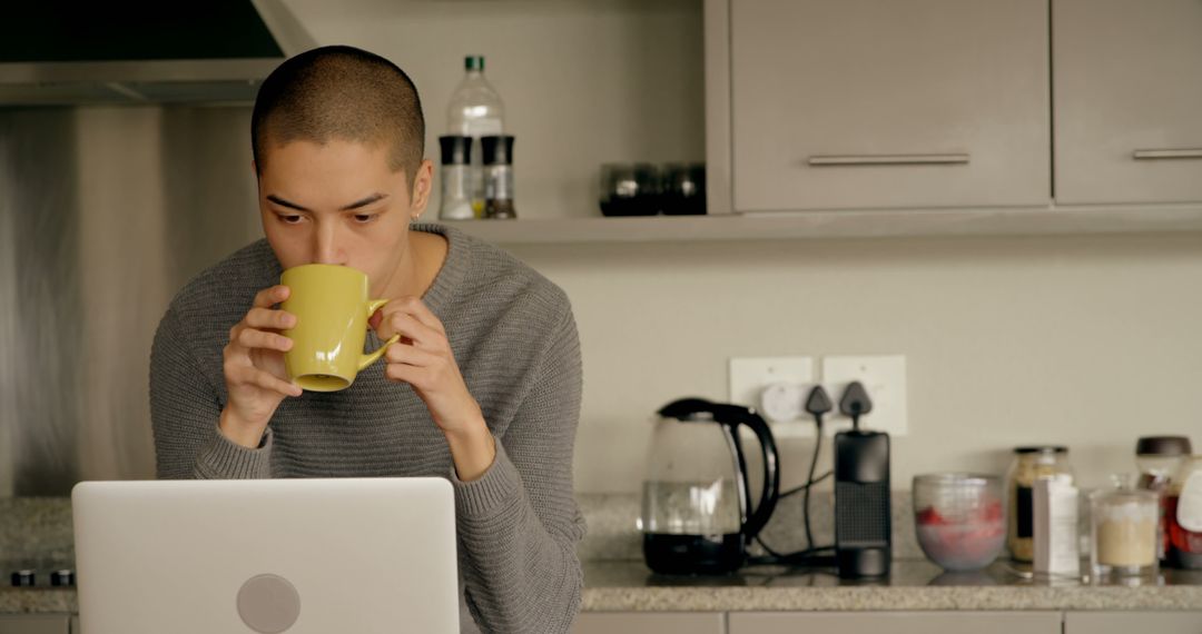 Young Man Working From Home With Laptop and Coffee in Kitchen - Free Images, Stock Photos and Pictures on Pikwizard.com