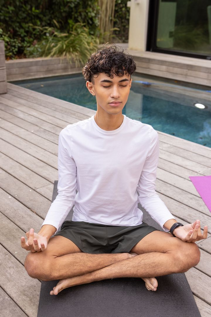 Young Man Meditating Outdoors by Pool in Serenity