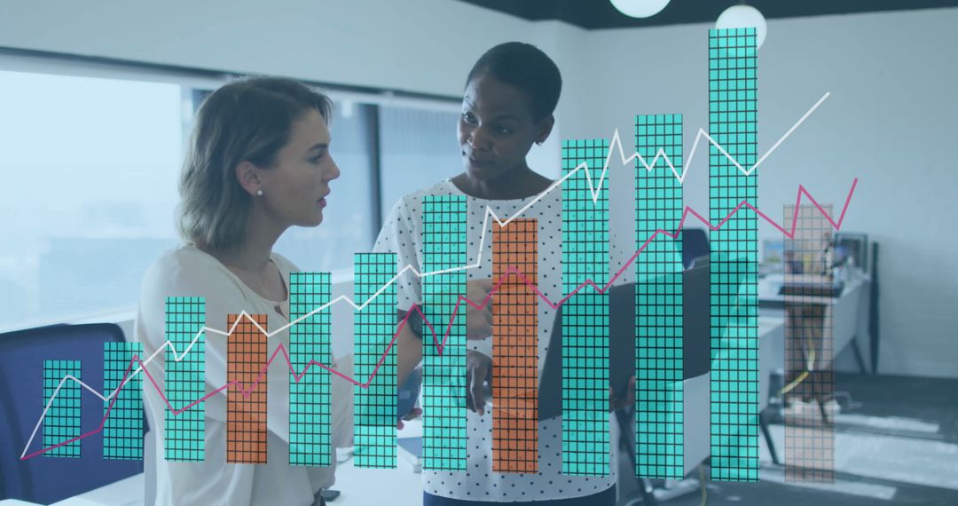 Businesswomen Discussing Data and Strategy with Overlaying Charts