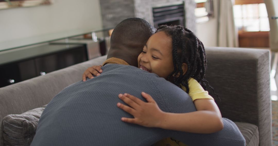 Joyful Father and Daughter Hugging at Home Creating Memories