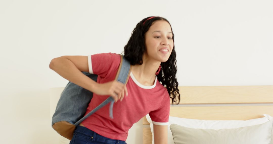 Student Packing Backpack on Her Bed