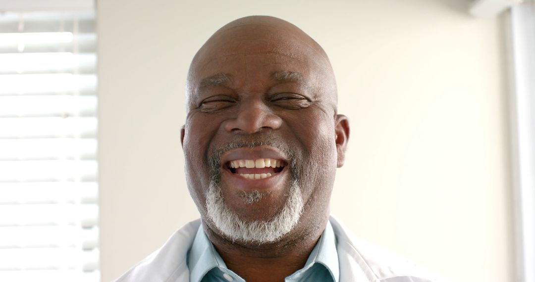 Smiling African American doctor in white coat with bright background - Free Images, Stock Photos and Pictures on Pikwizard.com