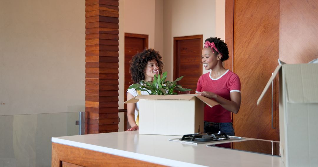 Lesbian Couple Unpacking Boxes and Arranging Plants in New Home