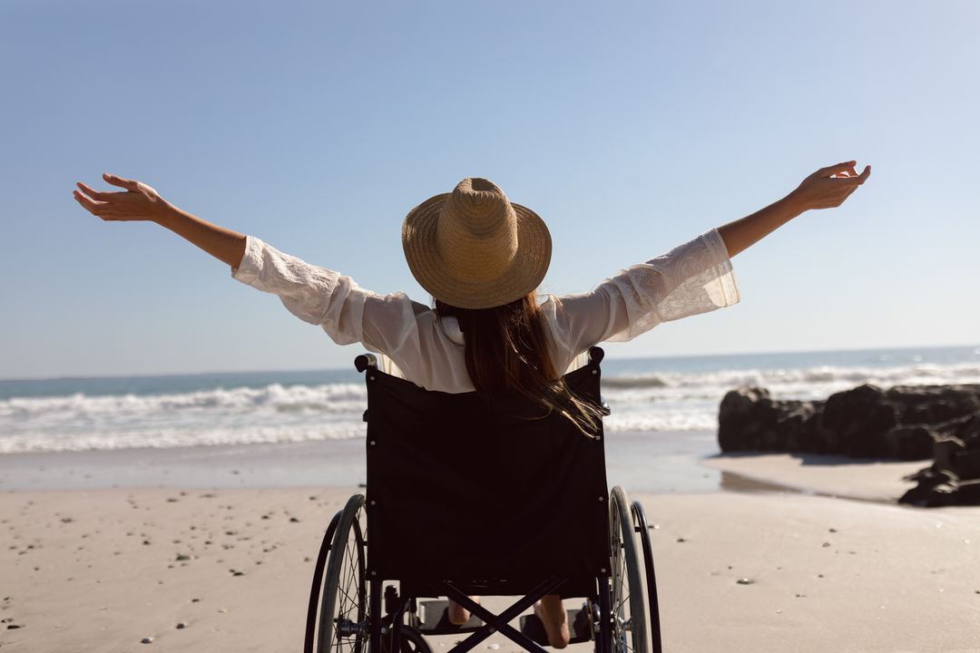 Disabled woman with arms outstretched on the beach - Free Images, Stock Photos and Pictures on Pikwizard.com