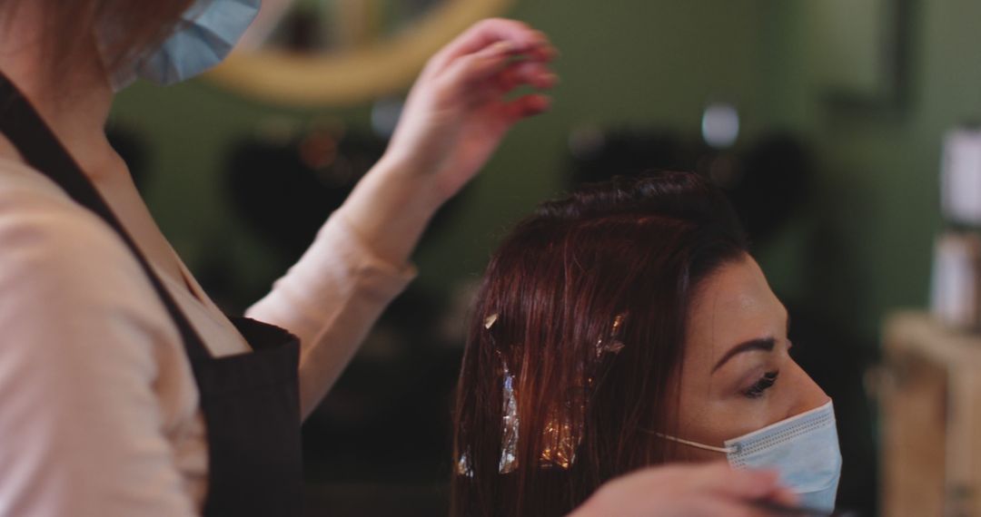 Hairdresser Highlighting Customer's Hair While Wearing Face Masks - Free Images, Stock Photos and Pictures on Pikwizard.com