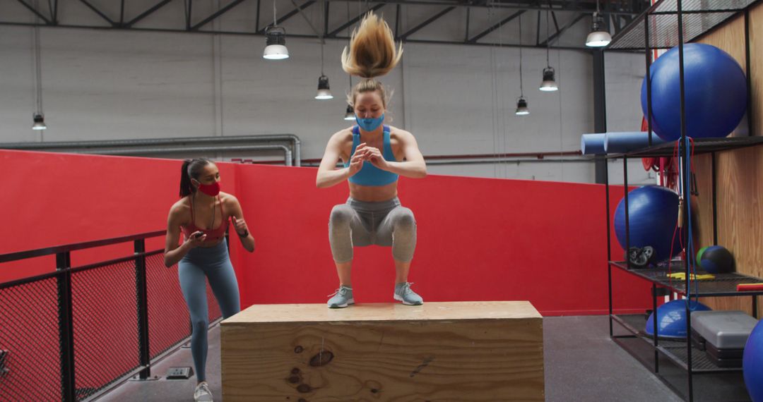 Women Exercising with Masks in Gym Doing Box Jumps - Free Images, Stock Photos and Pictures on Pikwizard.com