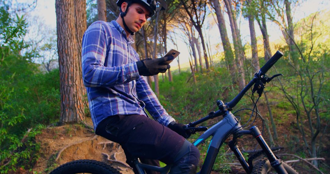 Mountain Biker Using Smartphone in Forest - Free Images, Stock Photos and Pictures on Pikwizard.com