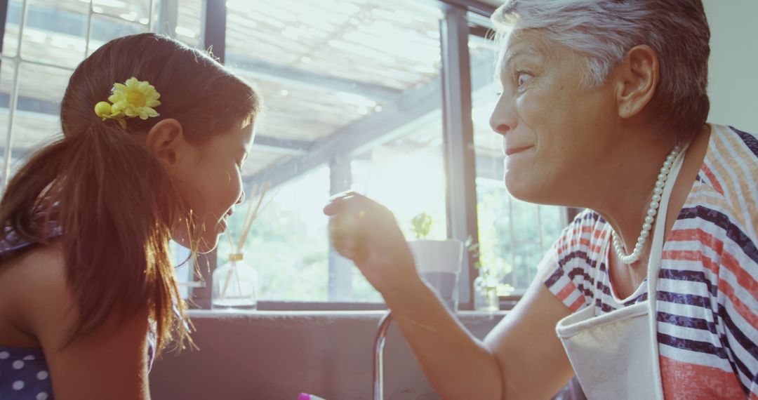 Grandmother Teaching Young Girl in Sunlit Kitchen - Free Images, Stock Photos and Pictures on Pikwizard.com