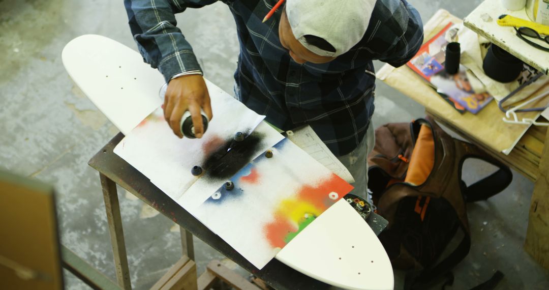 Young Man Customizing Skateboard Deck with Spray Paint - Free Images, Stock Photos and Pictures on Pikwizard.com