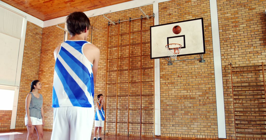 Young Basketball Player Focused on Hoop During Indoor Practice